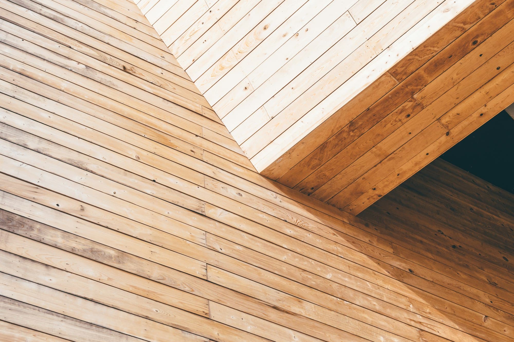 Close-up of pale timber cladding boards meeting at a corner
