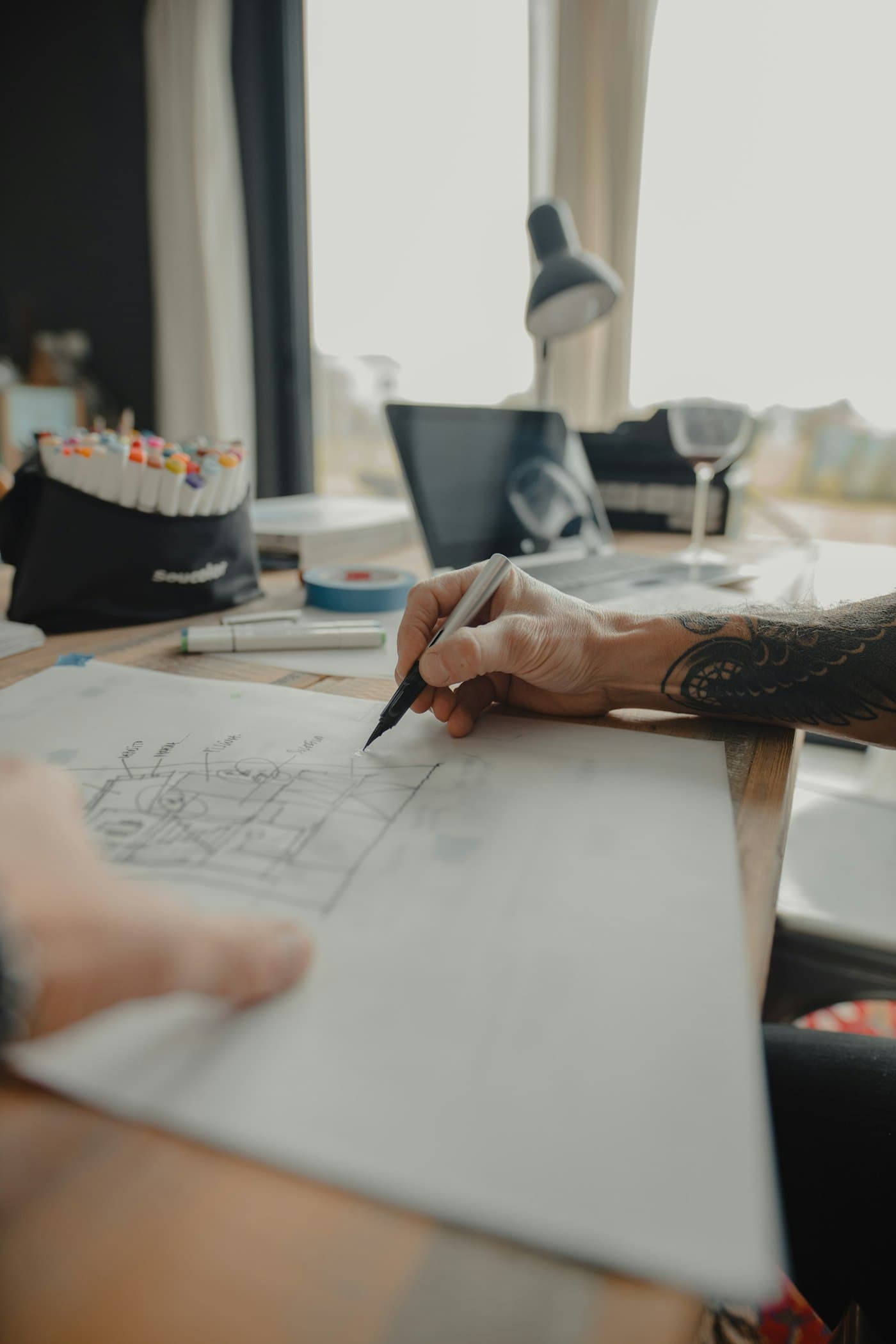 A hand drawing building plans in pencil