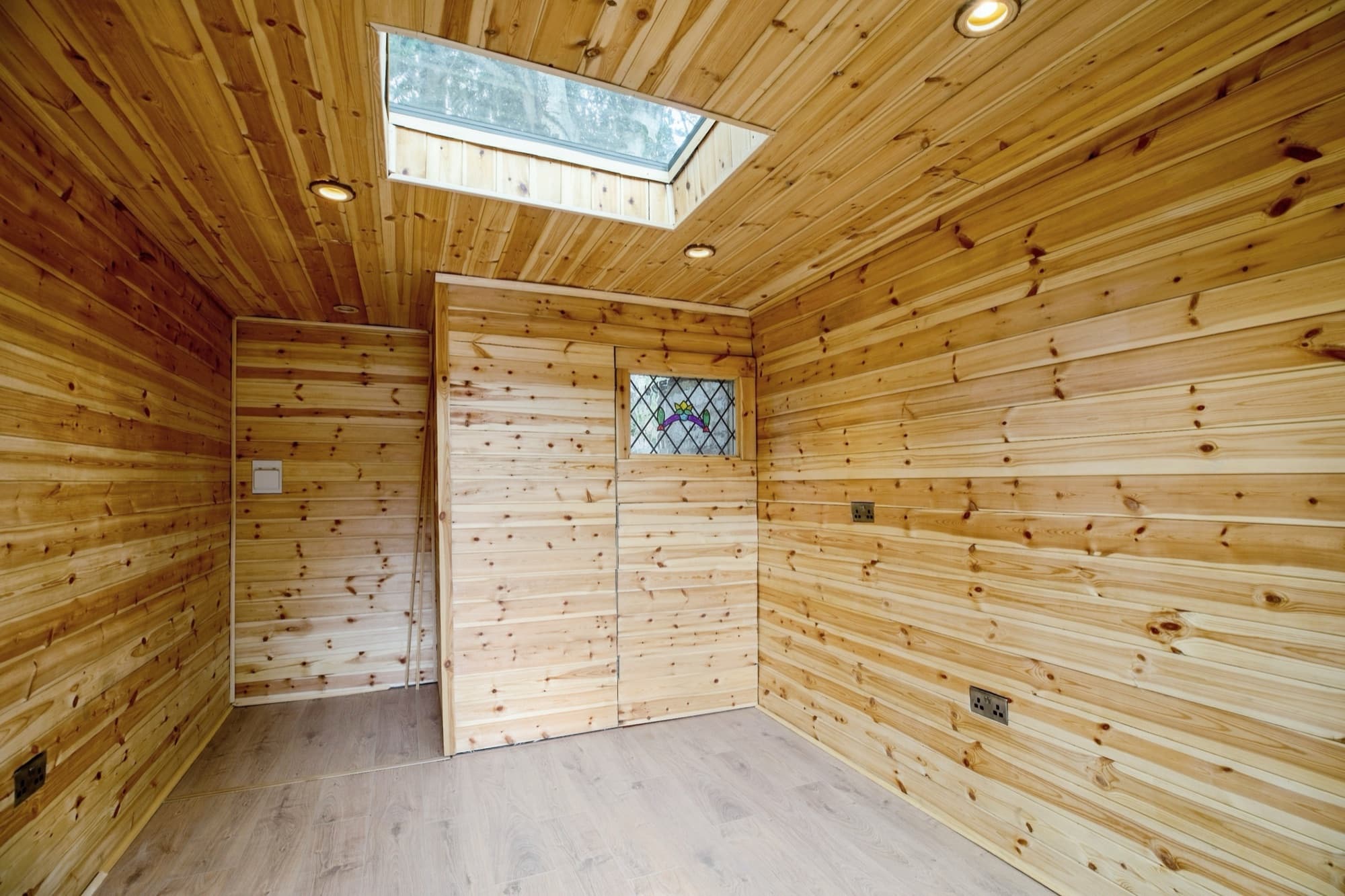 Inside a timber-lined garden room, with a skylight, recessed lights and sockets, ready to furnish