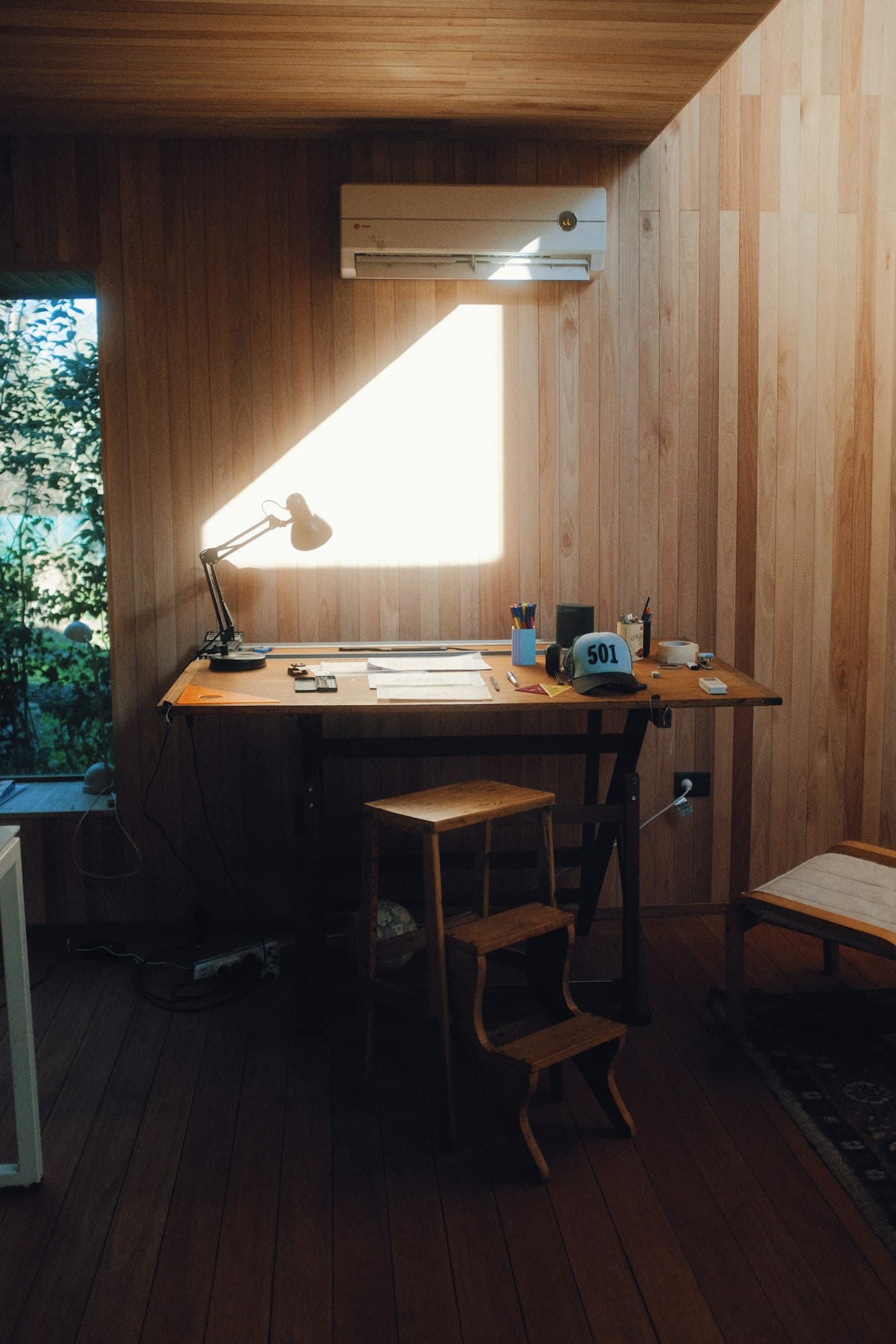 A timber-lined desk nook lit by a single window