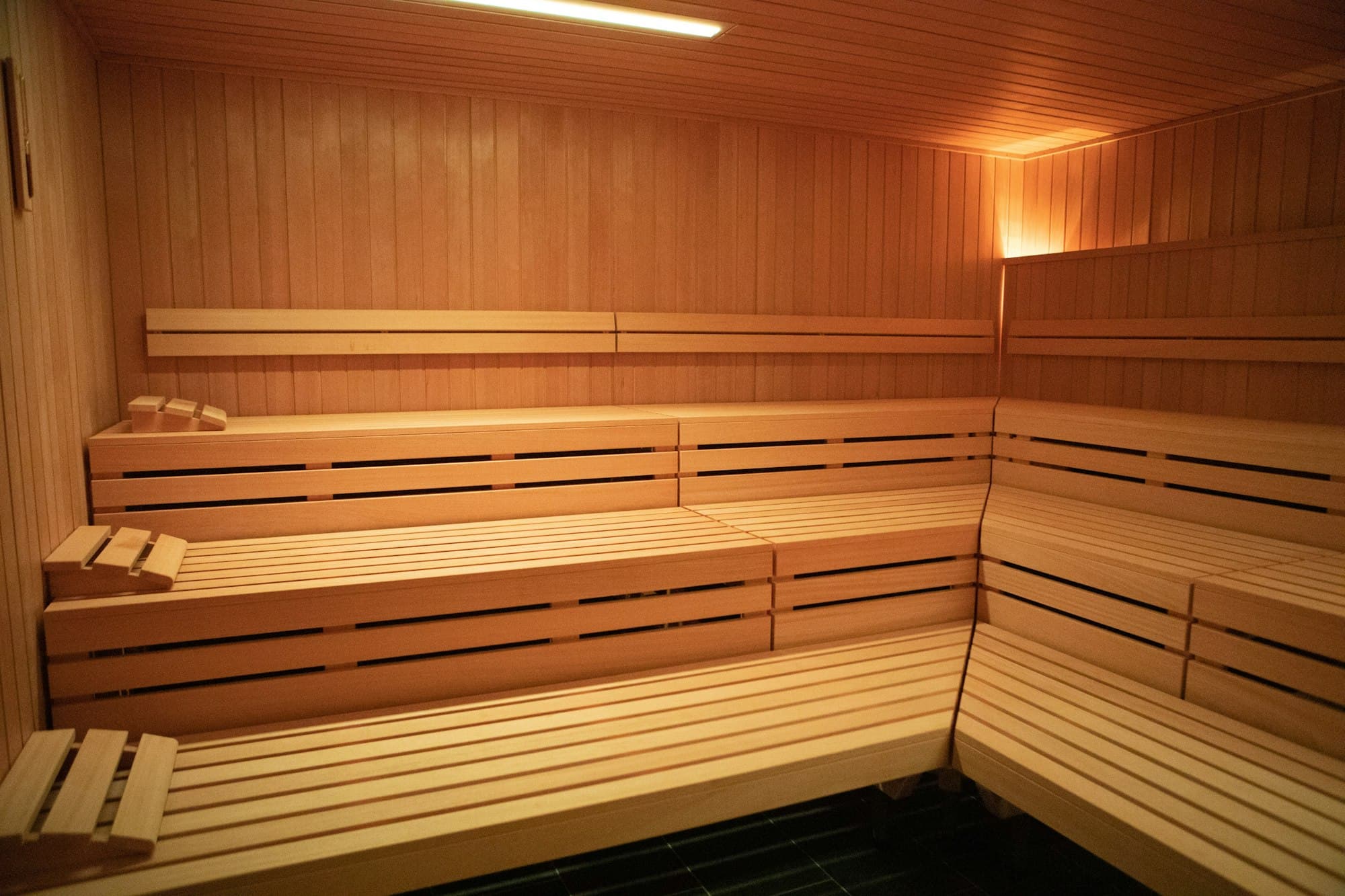 Pale timber sauna benches with concealed lighting