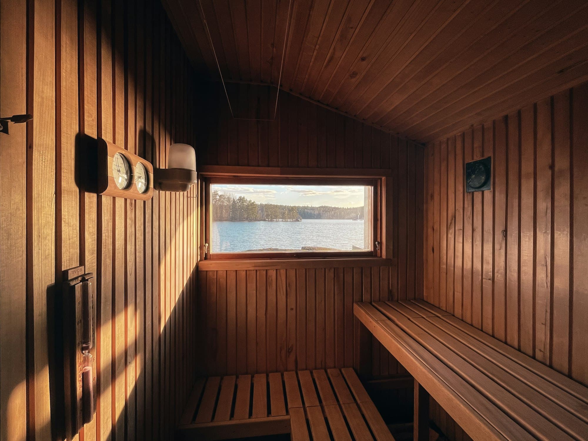 A timber-lined sauna with a bench and a window
