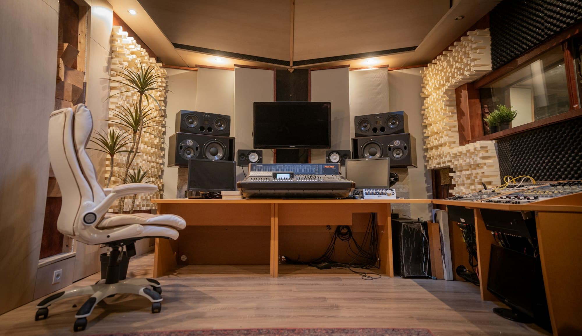 A music room with studio monitors, a mixing desk and acoustic treatment