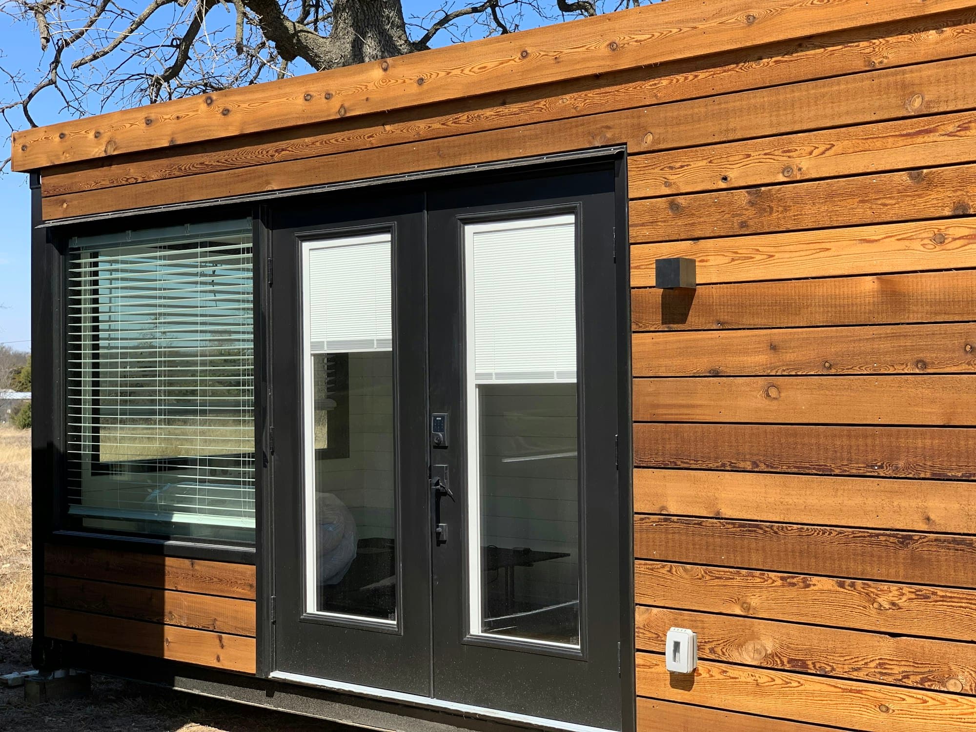 Horizontal timber cladding with black-framed glazed double doors