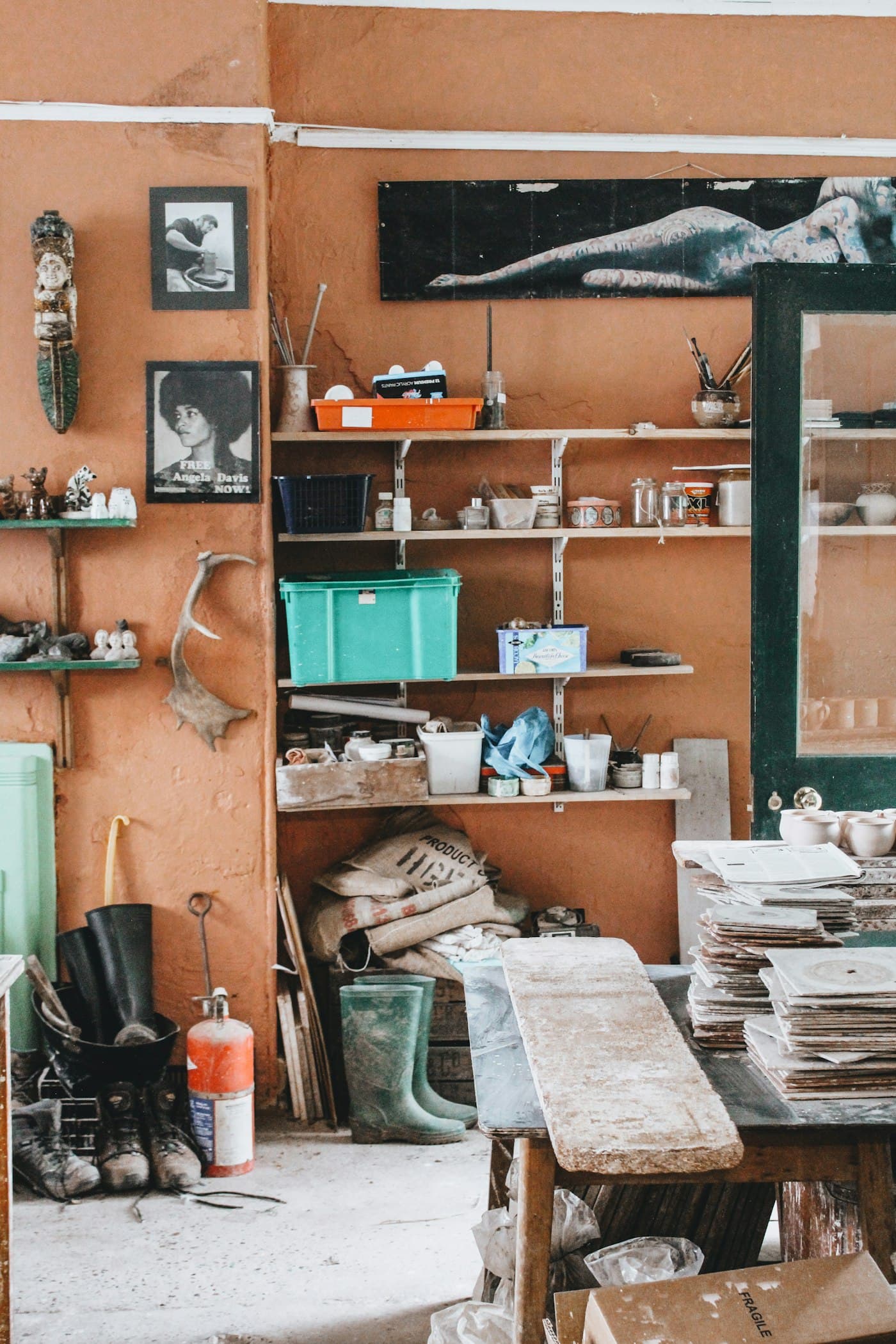 Studio shelves stacked with tools, pots and materials